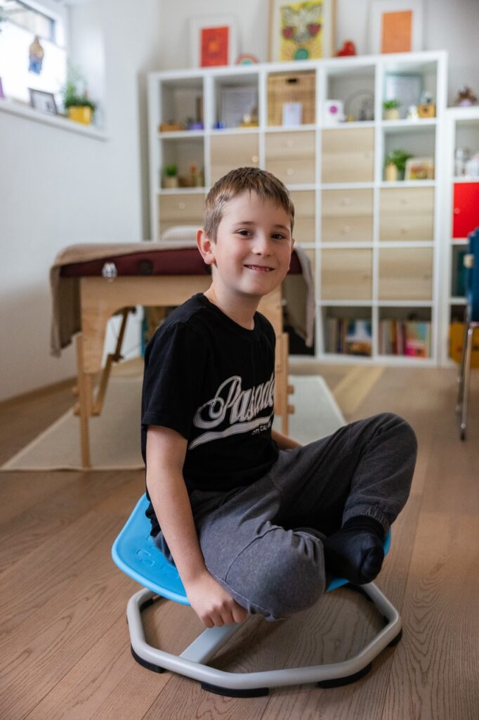 Lächelnder Junge sitzt entspannt in der Praxis