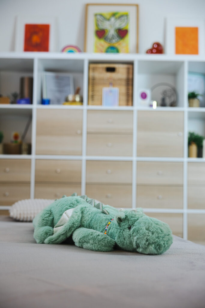 Behandlungsliege mit Kuscheltier in entspannter Praxisatmosphäre